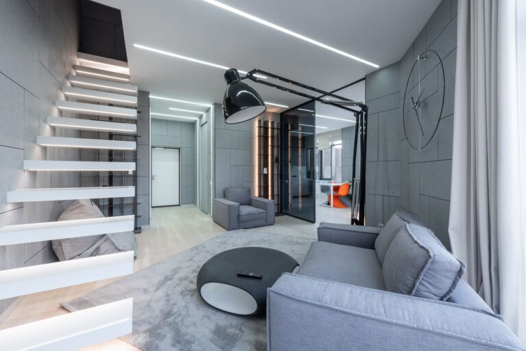 Loft moderne spacieux avec mobilier élégant, éclairage lumineux et escalier flottant.