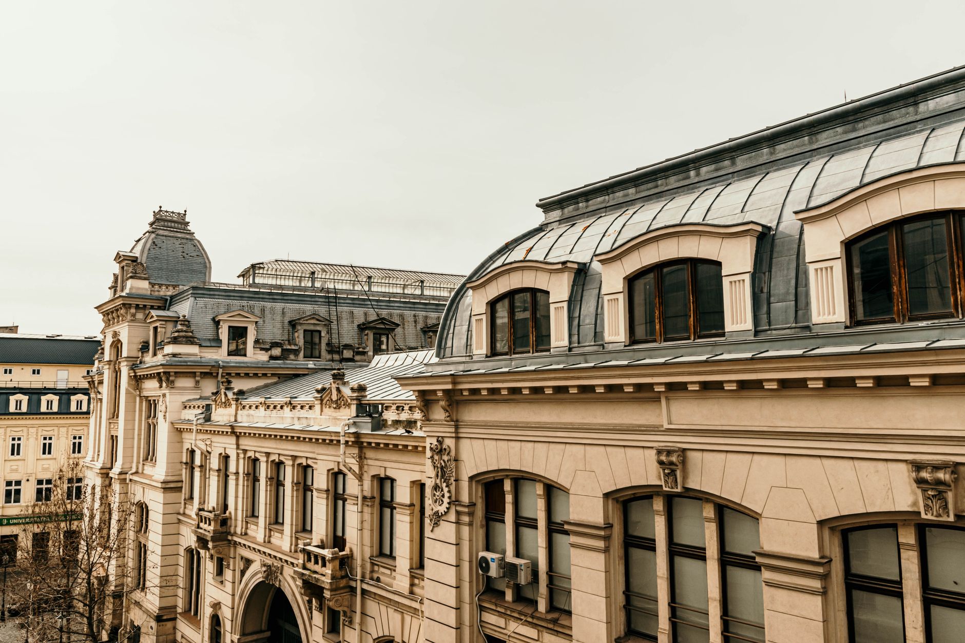 Immeubles anciens, toits en zinc et façades ornées dans un centre historique urbain.